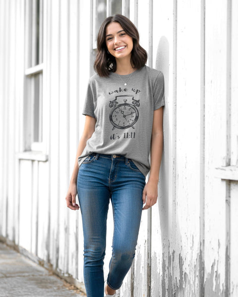 Woman wearing a heather gray unisex T‑shirt with a vintage 11:11 angel number clock design.
