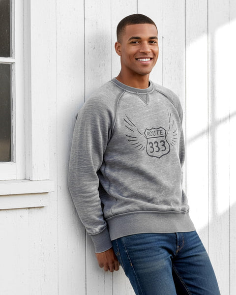 Man wearing a gray vintage‑style 333 angel number crewneck sweatshirt with a distressed, burnout fleece look.