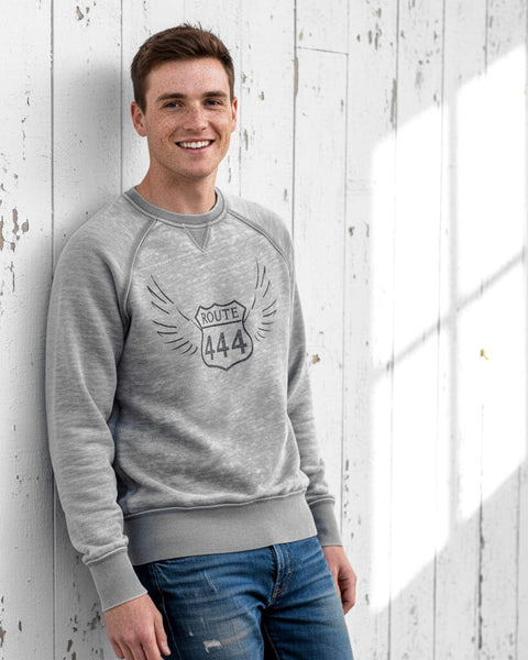 Man wearing a gray vintage‑style 444 angel number crewneck sweatshirt with a distressed, burnout fleece look.